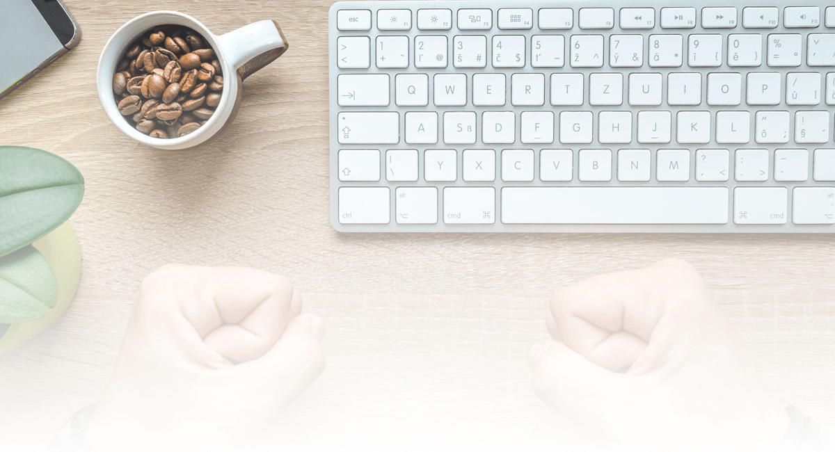 A keyboard and coffee cup on a table 